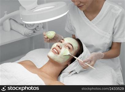beautician applying face mask female client 6