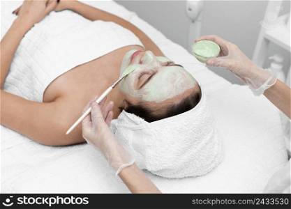 beautician applying face mask female client 7