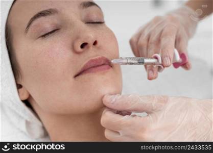 beautician doing filler injection female client 2