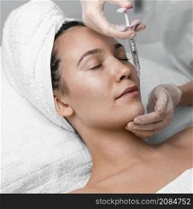 beautician doing filler injection female client