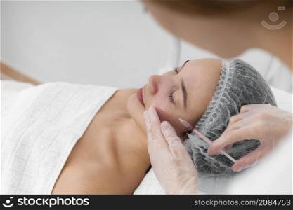 beautician doing injection filler female client