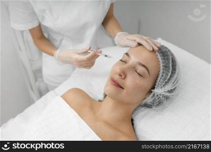 beautician doing injection filler female client salon