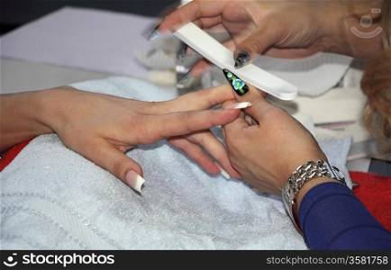 Beautician in a salon manicure fingernails a female person