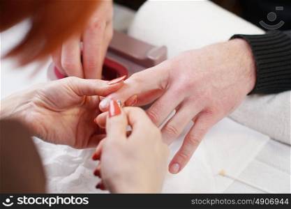 Beautician is doing manicure to her costumer
