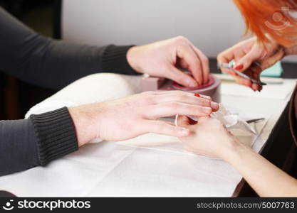 Beautician is doing manicure to her costumer