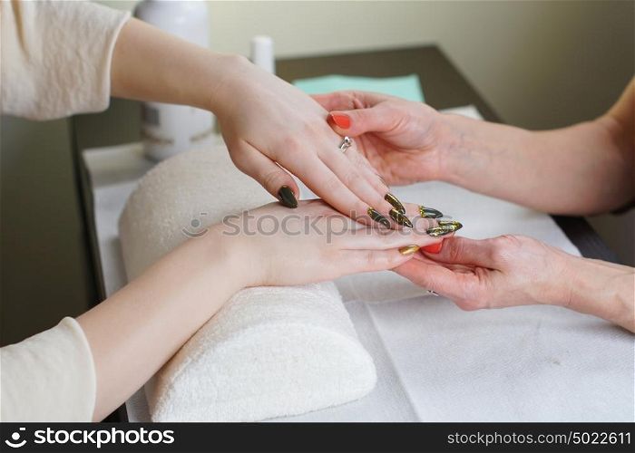 Beautician is doing manicure to her costumer