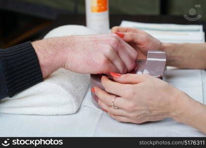 Beautician is doing manicure to her costumer