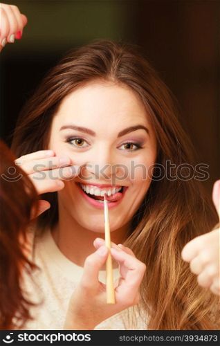 Beautician making makeup for smiling, girl. Woman take care about look in salon
