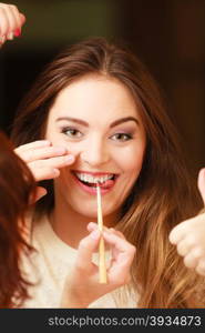 Beautician making makeup for smiling, girl. Woman take care about look in salon