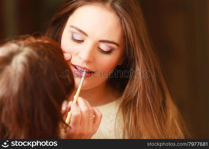 Beautician making makeup for young girl. Beautician making makeup for young girl. Woman take care about look in salon