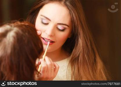 Beautician making makeup for young girl. Beautician making makeup for young girl. Woman take care about look in salon