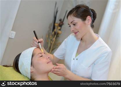 beautician using brush across clients forehead