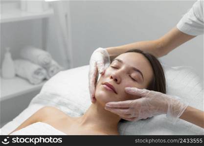 beautician with female client salon face care routine