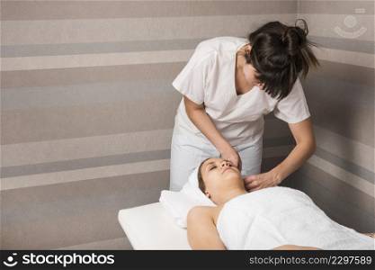 beautician wrapping towel relaxed young woman s head spa