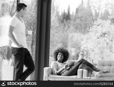 Beautifl black girl using tablet while lying on couch with her friend