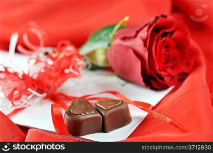 beautifu rose, chocolate and letter on red close up