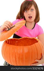 Beautiful 10 year old girl with giant empty pumpkin and surprised expression over white background.