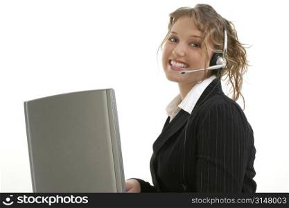 Beautiful 16 year old teen in suit at laptop wearing headset.