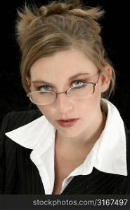 Beautiful 25 year old woman in suit over black. Wearing eyeglasses.