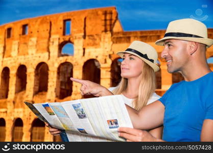 Beautiful active couple with map standing on Coliseum background and looking for right way, travel to Rome and exploring it by themselves, Italy Europe