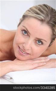 Beautiful adult blond woman on massage bed