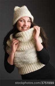 Beautiful adult woman wearing knitted wear, gray background