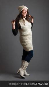 Beautiful adult woman wearing knitted wear, gray background