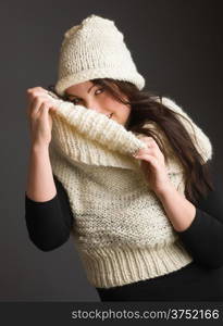 Beautiful adult woman wearing knitted wear, gray background