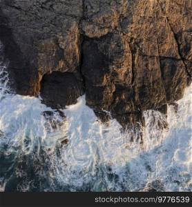 Beautiful aerial drone landscape image of bird’s eye view of waves crashing over rocks at shore