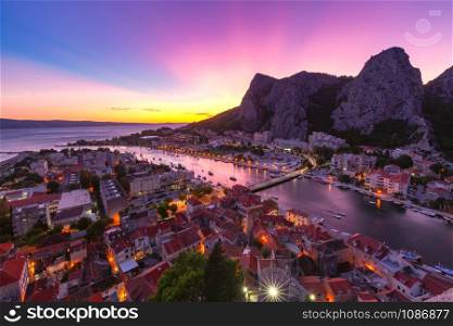Beautiful aerial panoramic view of Cetina river, mountains and Old town at sunset, Omis, very popular tourist spot in Croatia. Panorama of Omis, Croatia