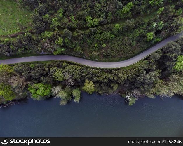 Beautiful aerial view of road between forest and Nalon river in Candamo, Asturias Spain.