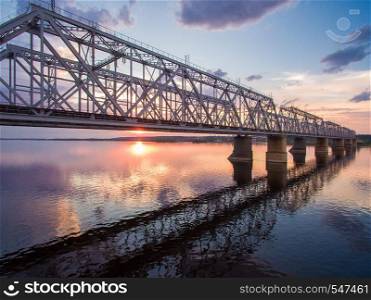beautiful aerial view of the railway bridge across the Volga river at sunset. It connects two banks via the river Volga. beautiful aerial view of the railway bridge across the Volga river at sunset