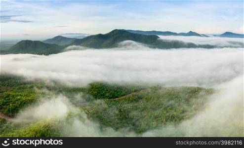 Beautiful aerial view sea of fog in the morning forest mountent with green mountains and road. Nong Ya Plong, Phetchaburi, Thailand. Aerial view Fog in forest.