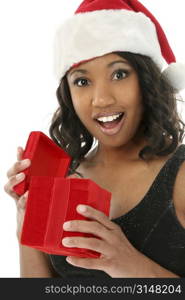 Beautiful African American woman in Santa hat and formal dress opening a red velvet gift box.