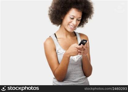 Beautiful African American woman sending a sms on cell phone, isolated on white background