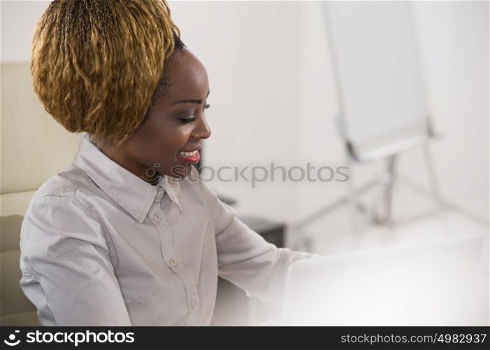 Beautiful african business woman working at office using laptop