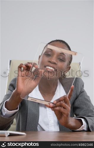 Beautiful african modern businesswoman holding tablet computer at her workplace at office