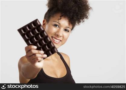 Beautiful african woman holding a huge dark chocolate bar
