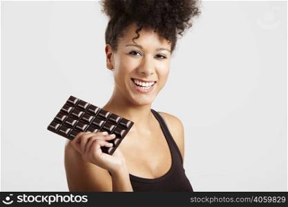 Beautiful african woman holding a huge dark chocolate bar