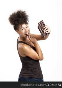 Beautiful african woman holding and eating a huge dark chocolate bar