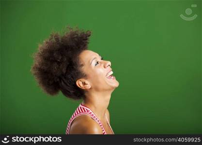 Beautiful African woman laughing over a green background