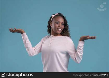 Beautiful African woman making a scale with her arms wide open on blue background