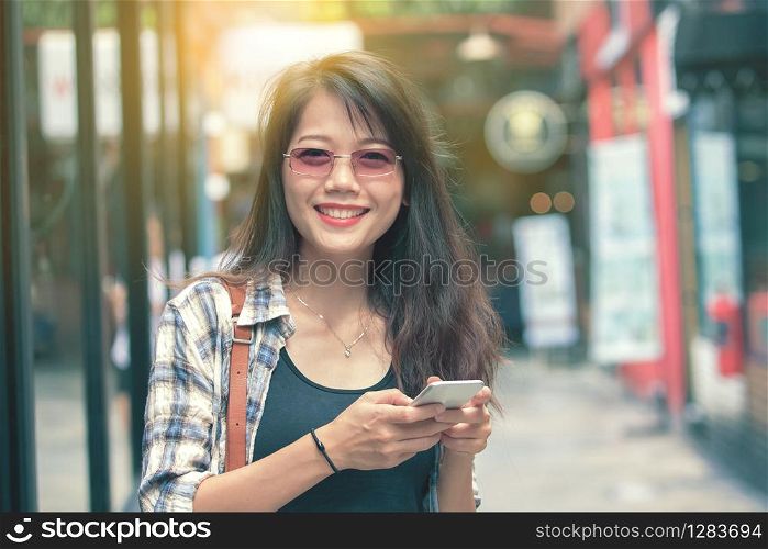 beautiful aisan woman toothy smiling face with smart phone in hand happiness emotion