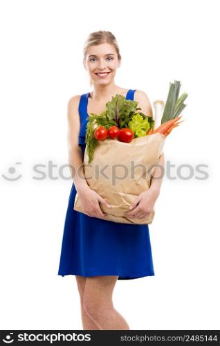Beautiful and attractive woman carrying a bag full of vegetables, isolated over white background