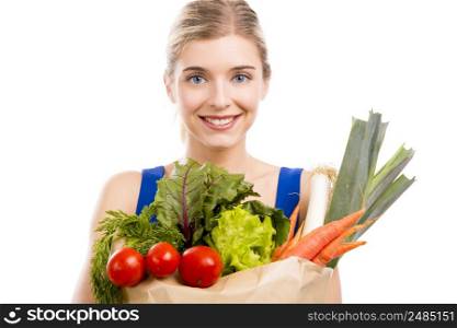 Beautiful and attractive woman carrying a bag full of vegetables, isolated over white background