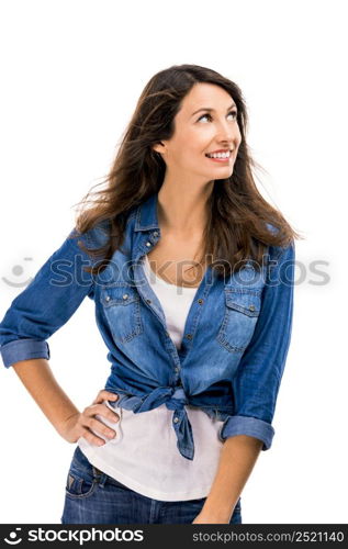 Beautiful and attractive woman wearing a jeans shirt and thionking on something, isolated over white background. Woman thinking