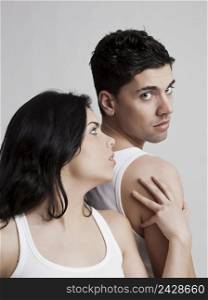 Beautiful and attractive young couple isolated on a gray background