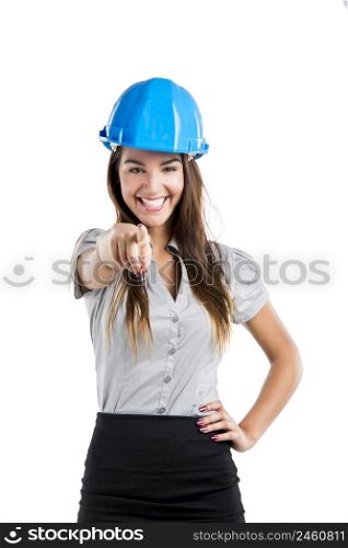 Beautiful and confident young female architect wearing a blue helmet and pointing, isolated on white