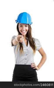 Beautiful and confident young female architect wearing a blue helmet and pointing, isolated on white