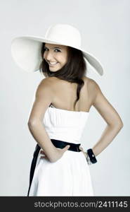 Beautiful and fashion young woman posing and wearing a wonderful white dress with a white hat